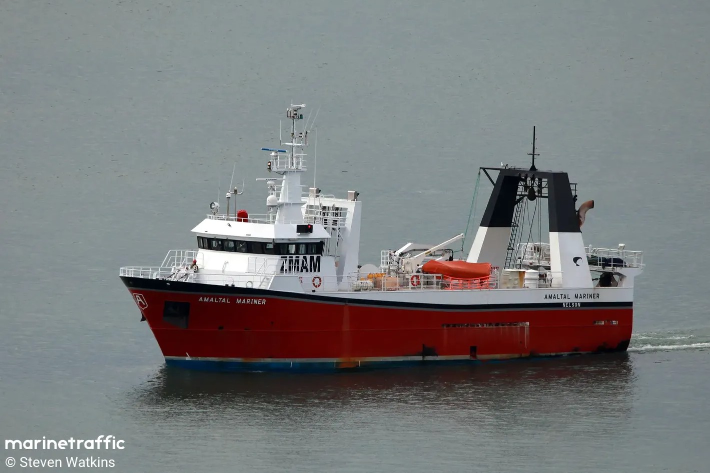 a trawler on calm sea under an overcast sky