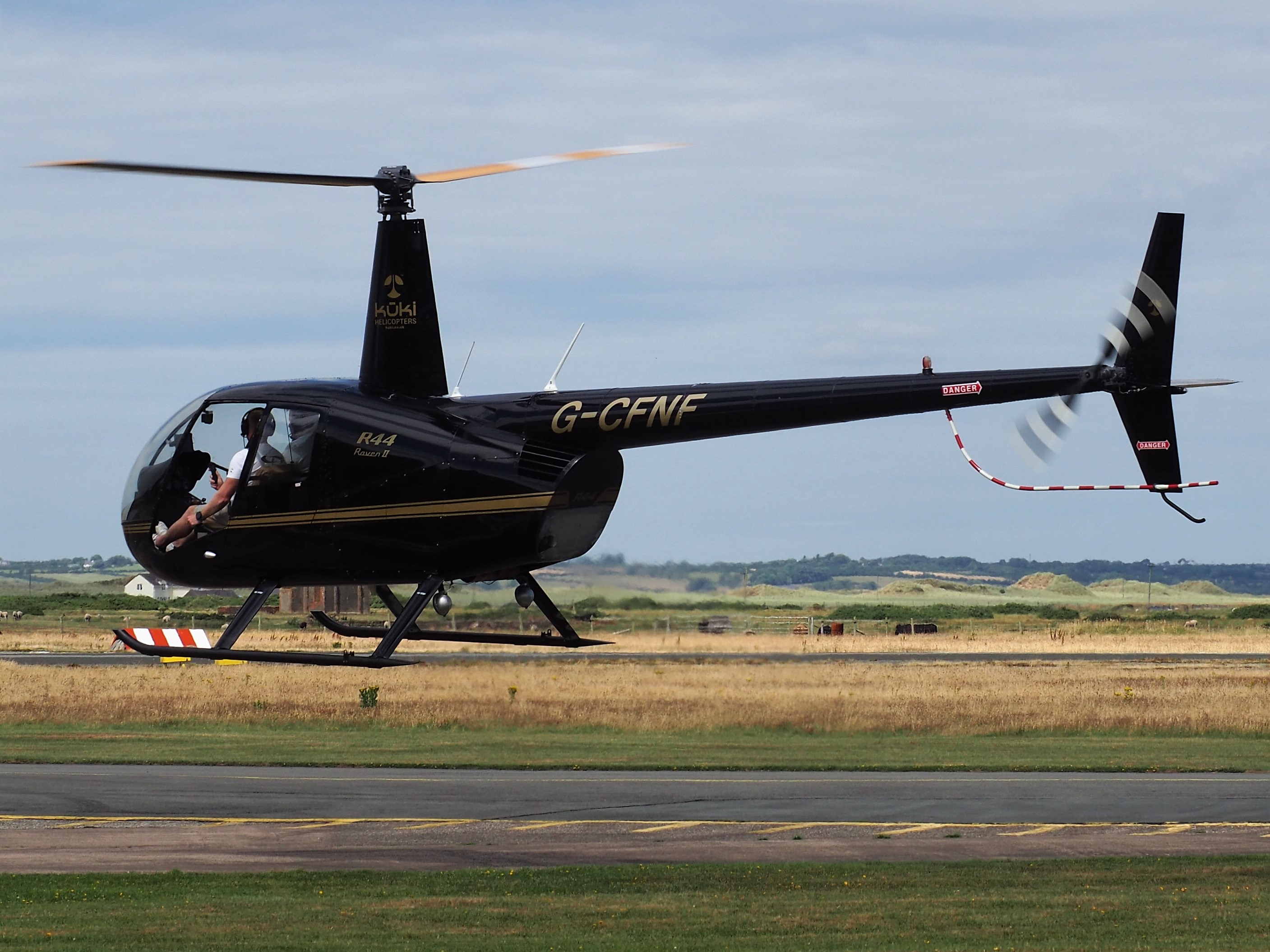 Photo of Robinson R44 helicopter registered G-CFNF at lift-off