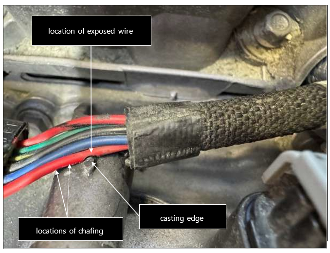 Damaged wire in situ with chafed area against casting edge