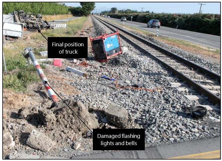 Damaged flashing lights and bells, and truck wreckage
