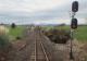 photo depicts re-enactment. In foreground right a stop signal on red. Rail tracks stretch from the viewer's feet into the distance straight ahead. A set of rail points in the middle distance provide access to a side track on the left. On this side track is a hi-rail vehicle with its headlights on, facing us. 