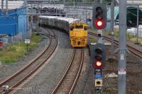 Te Huia photographed soon after the accident. End in view is the rear of the train. a passenger train stands stationary, across a set of points. In the foreground a rail traffic signal displays a red light. The parallel-converging track on the left is the one along which the metropolitan train was authorised to travel.