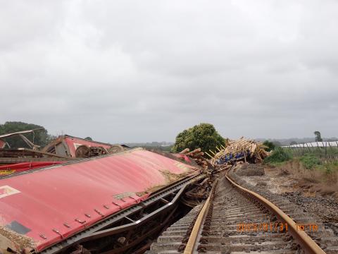 Freight wagons lie in their sides, beside tracks deformed by flood washout